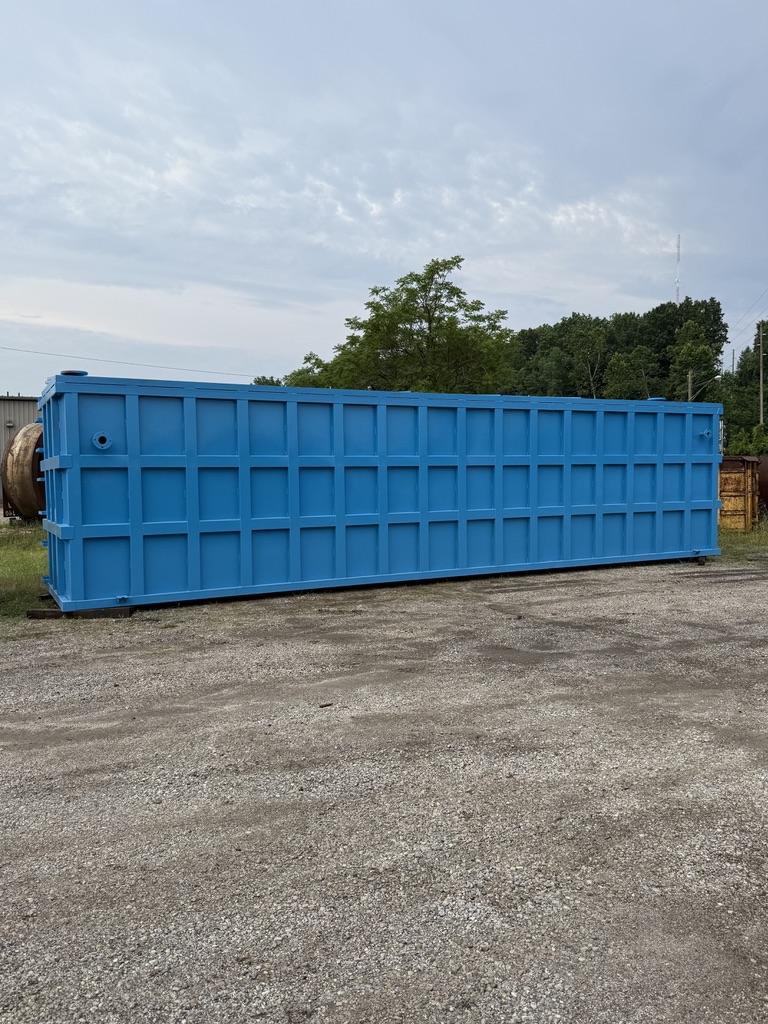 Coated blue EnviroBox tank in the yard showing the full-height rib grid in side profile