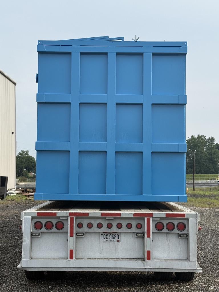 Rear end view of a blue EnviroBox tank loaded on a flatbed trailer for transport