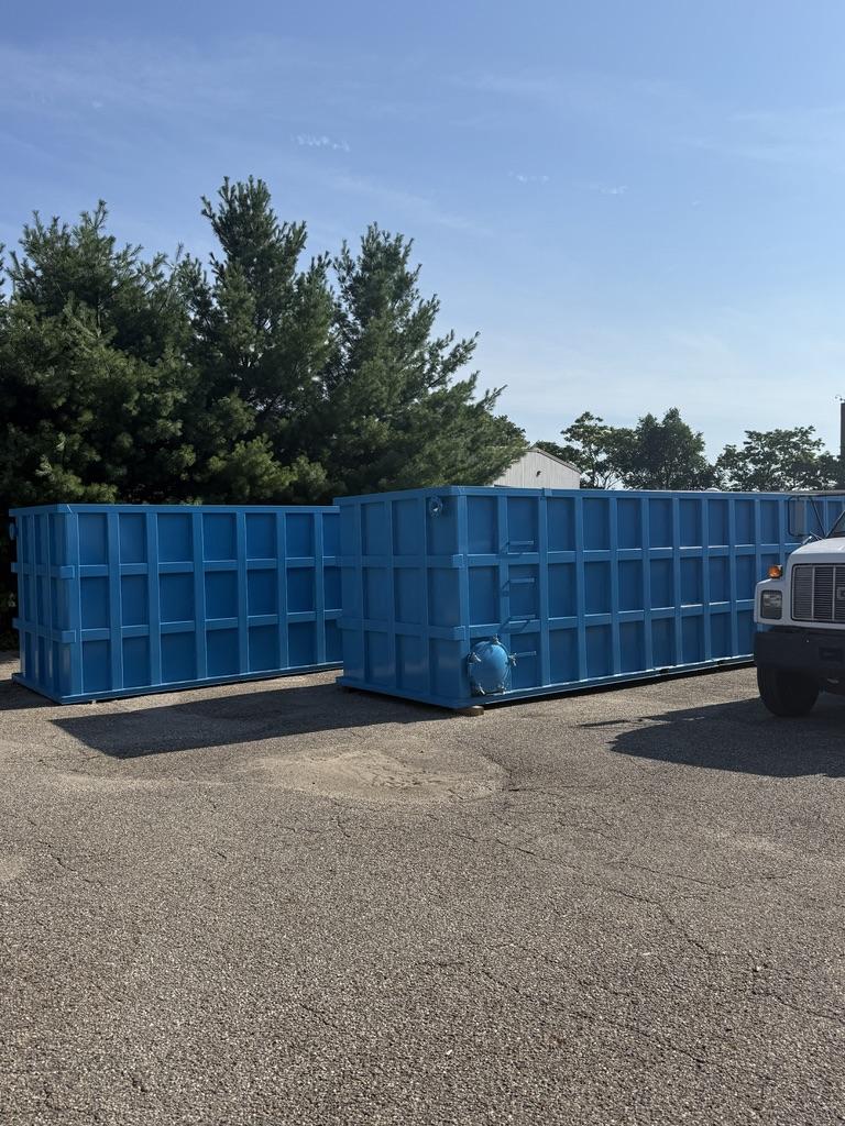Two coated blue EnviroBox tanks staged in the lot ready to ship