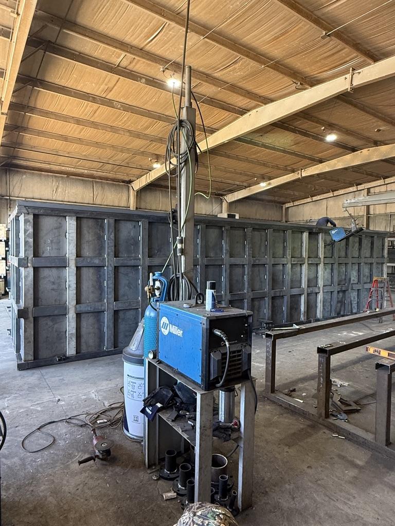 Miller welding station beside an EnviroBox shell mid-fabrication inside the Canton, Ohio shop